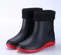 Men's mid-top PVC rain boots in black with green detailing, tassel decoration, and non-slip sole