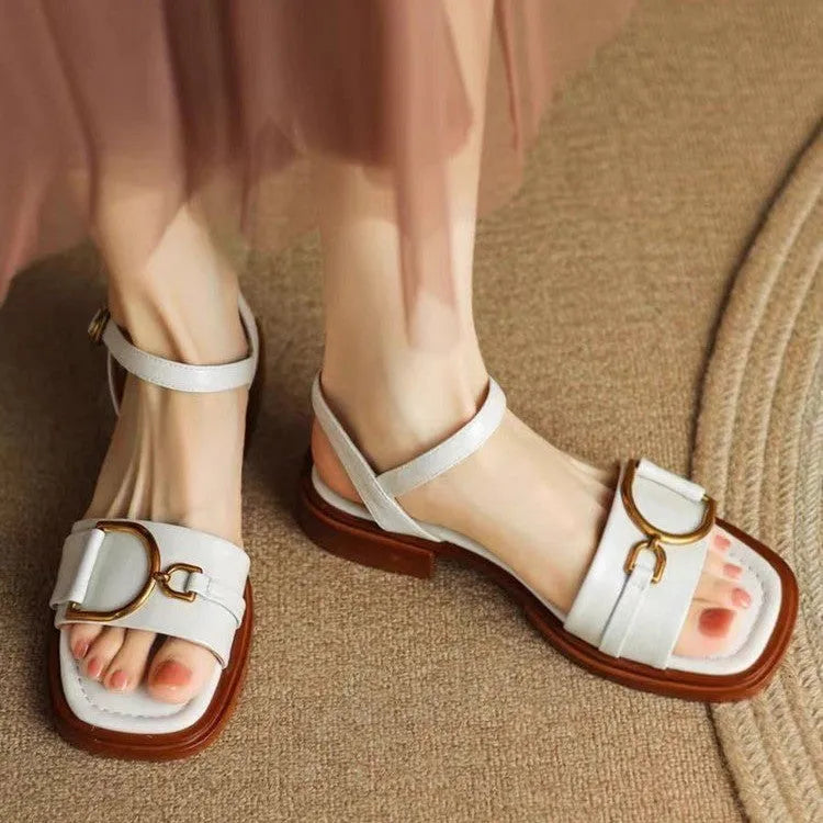 Women's black round-toe sandals with thick rubber sole and button fastening.