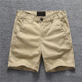 Youth cotton workwear shorts in camouflage green pattern with mid waist and zip fly.