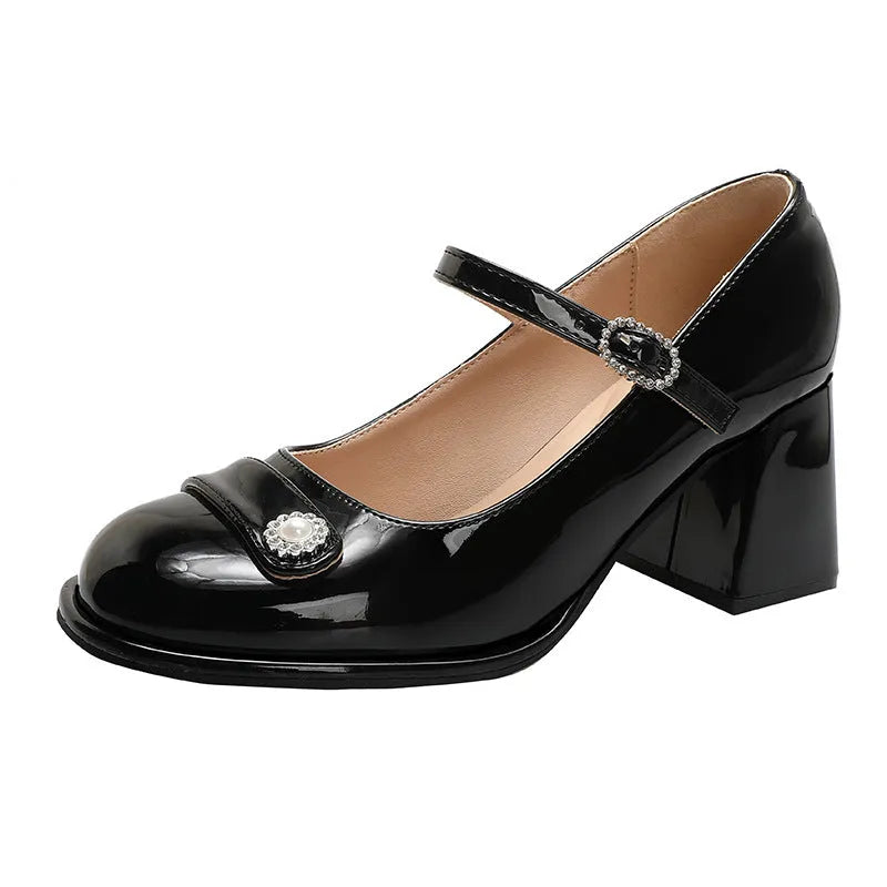 Women's black patent leather round toe chunky heels with a buckle strap, shown in a widened fit style.