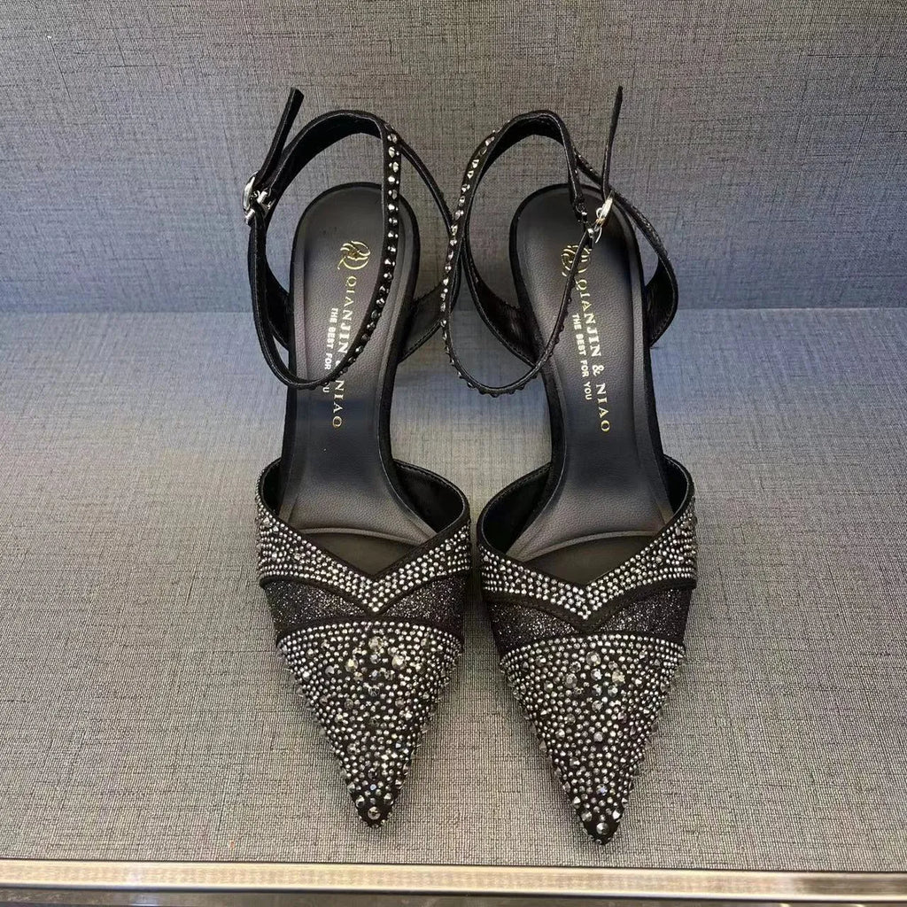 Women's black and silver hollow high heels with a red sole and pointed stiletto toe.
