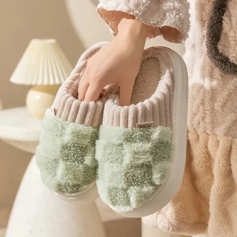 Plaid pattern women's plush slippers with round toe and flat heel on a coloured background.