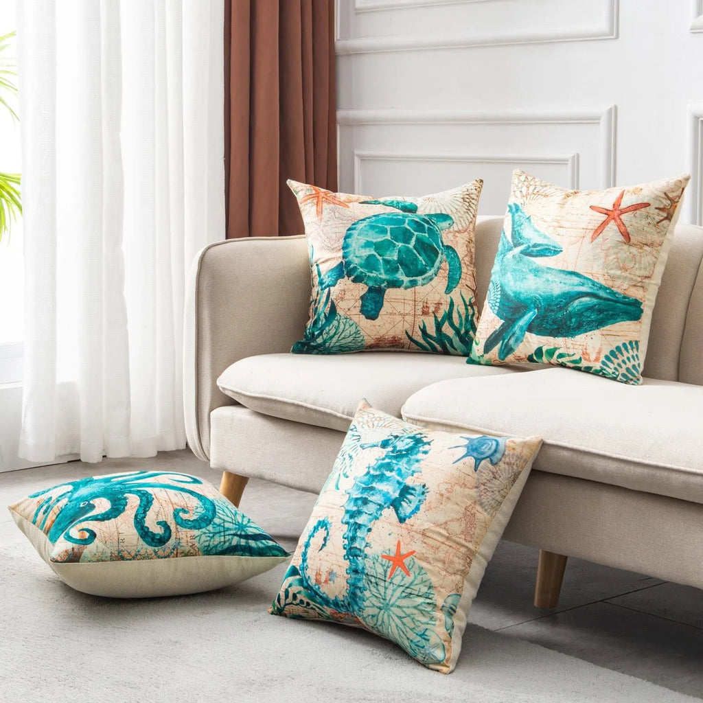 Square linen cushion cover with a detailed blue and green sea turtle print, shown on a grey sofa.