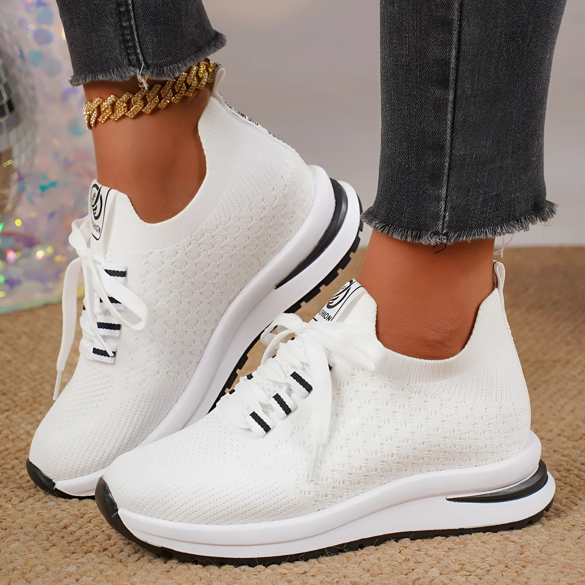 Black and white women's flat lace-up mesh sneakers with round toe on a rubber sole.