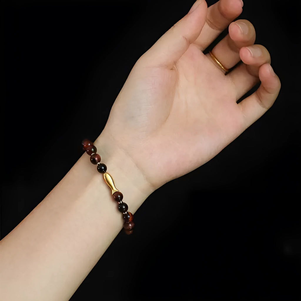 Handmade women's bracelet with tiger eye gemstone beads carved into small fish designs