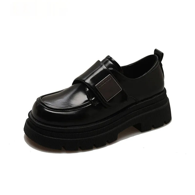 Women's black chunky square heel shoes with cross strap and round toe on a neutral background