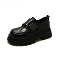 Women's black chunky square heel shoes with cross strap and round toe on a neutral background