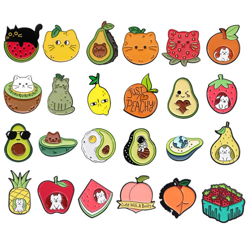 Colourful cartoon fruit and letter design on a silver-toned metal brooch pin.