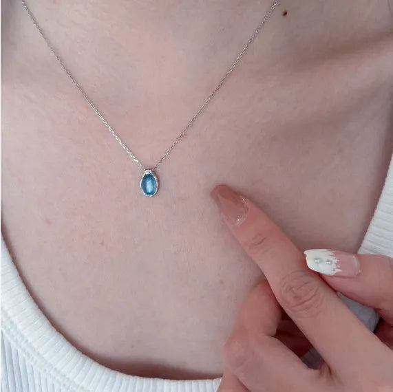 Geometric navy blue water drop pendant on an adjustable platinum-colour cross chain necklace.