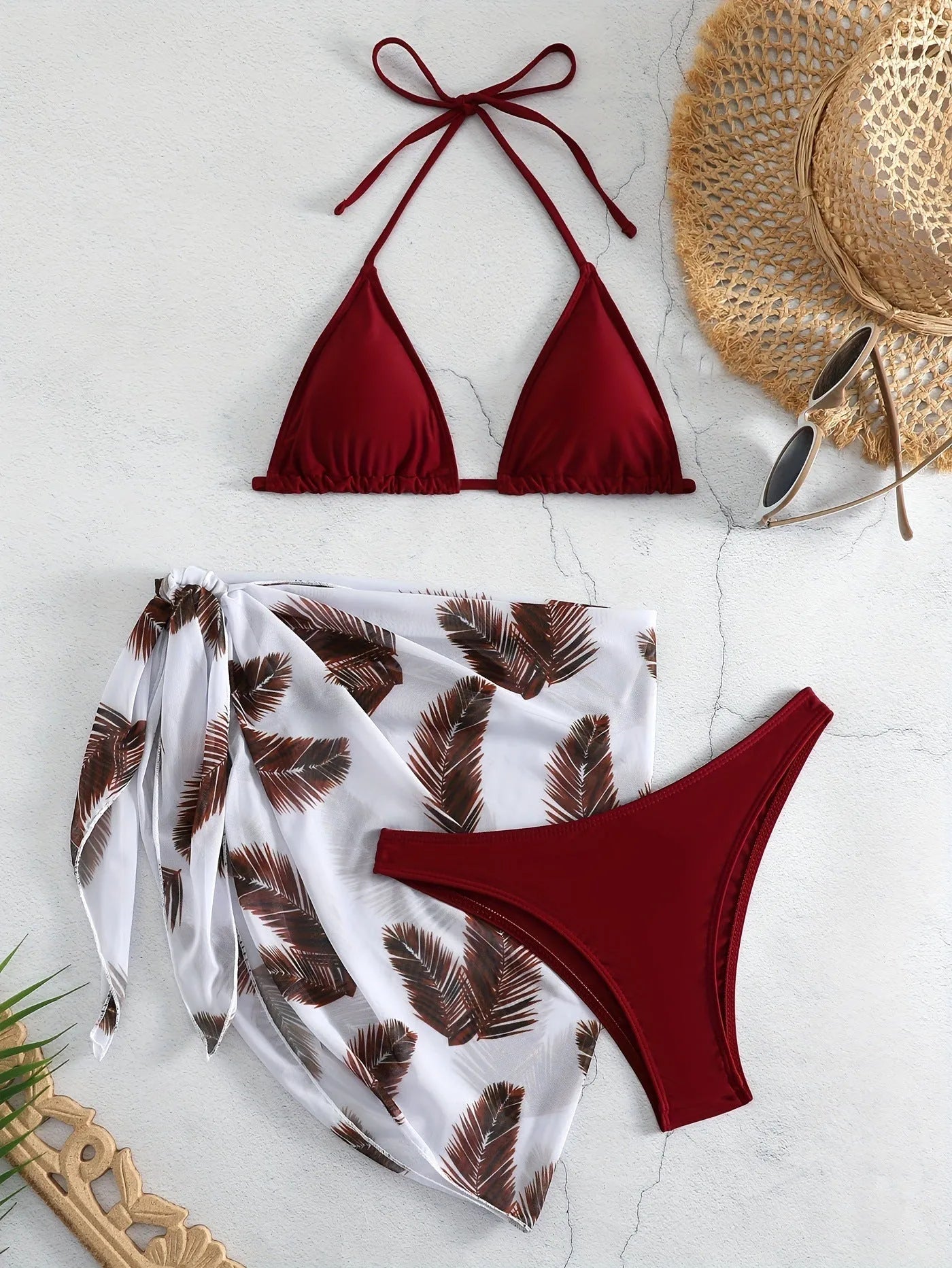 Women's orange three-piece bikini swimsuit set with a matching gauze skirt on a mannequin