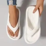 Women's black flip-flops with a thick textured sole and non-slip pattern.