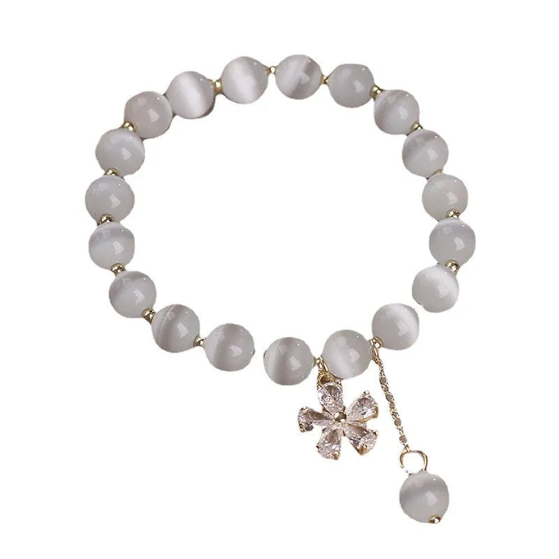 Women's white cat's eye crystal bracelet with flower tassel and morganite safety buckle.