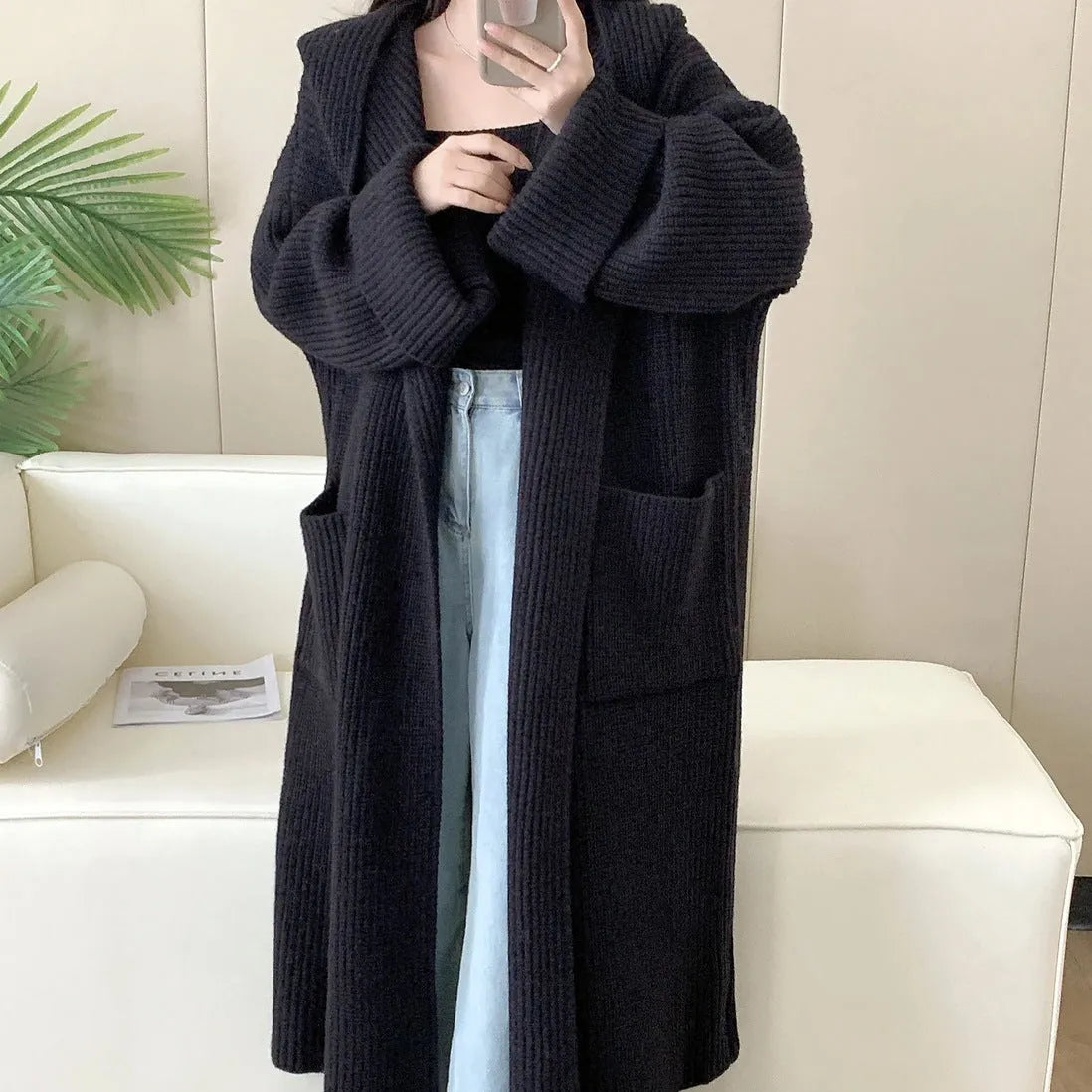 Loose grey hooded cardigan coat with long sleeves on a hanger