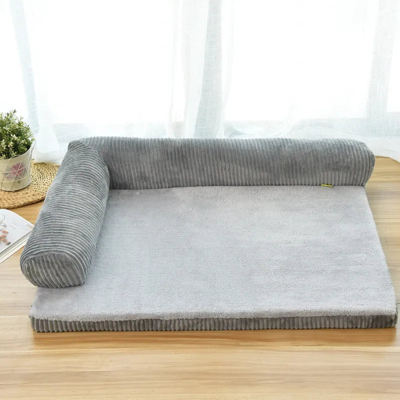 A corduroy pet sofa dog bed with bolsters, shown in a grey colour, placed on a hardwood floor.