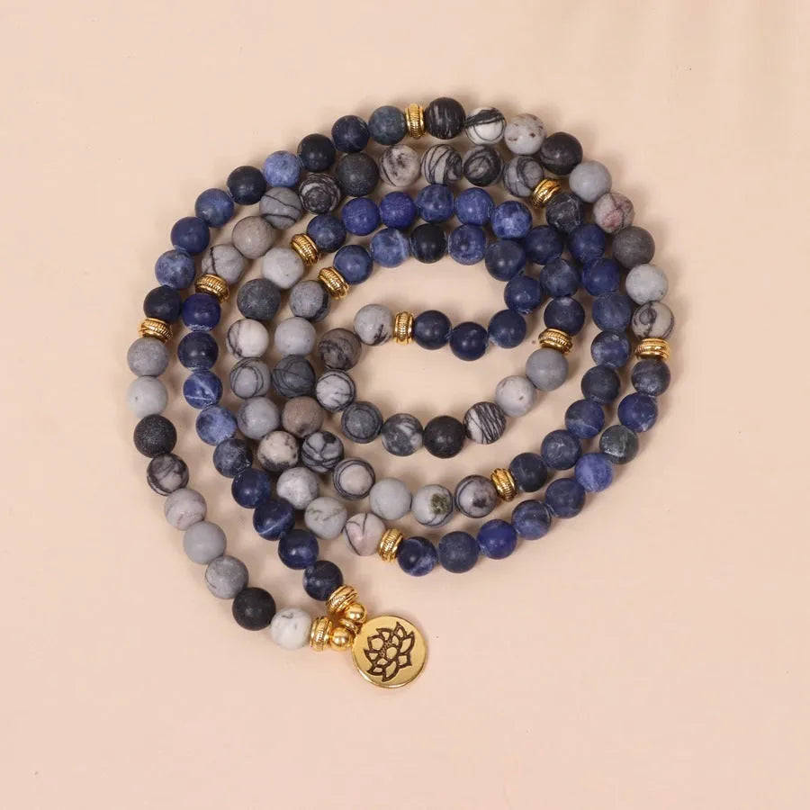 Blue patterned stone bead multi layer alloy bracelet with clasp on a white background.