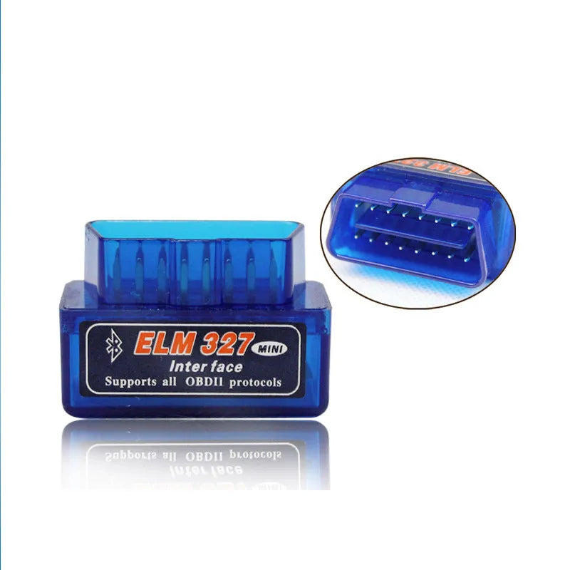 Small black Bluetooth OBD2 car diagnostic scanner next to a vehicle's diagnostic port