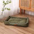 Grey waterproof dog sofa bed with padded sides on a wooden floor