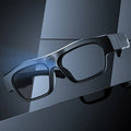 Black head-mounted smart glasses with camera and transparent lenses on a stand.