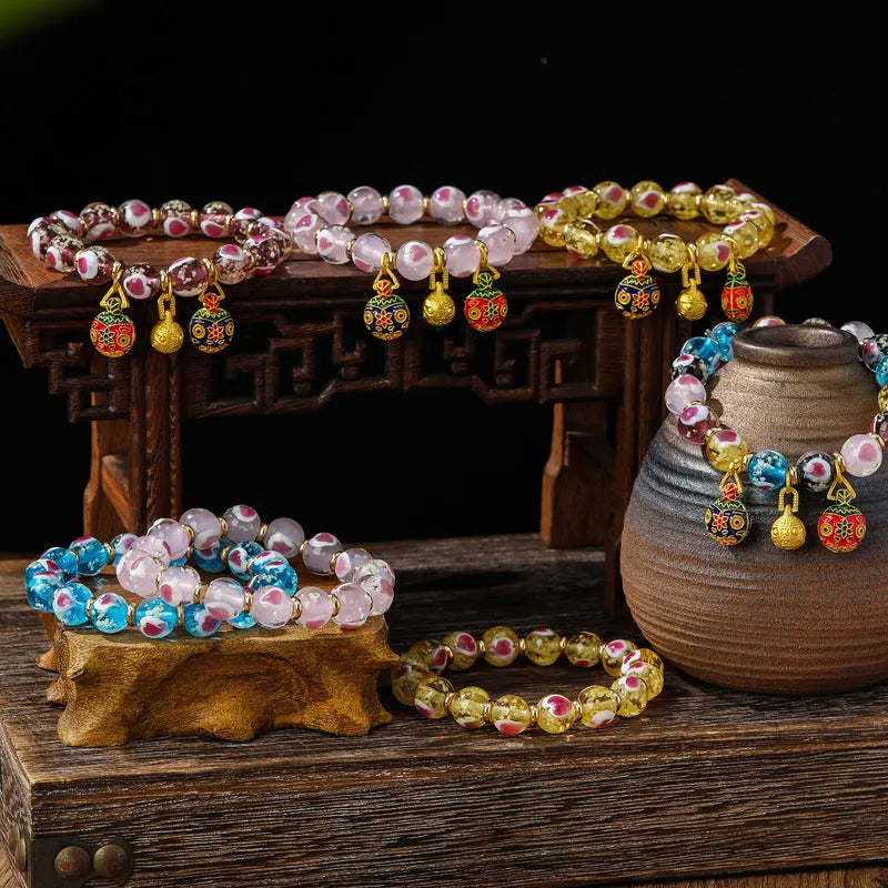 Handmade glass bracelet with swallowing gold beast design and cherry blossom heart in six colours.