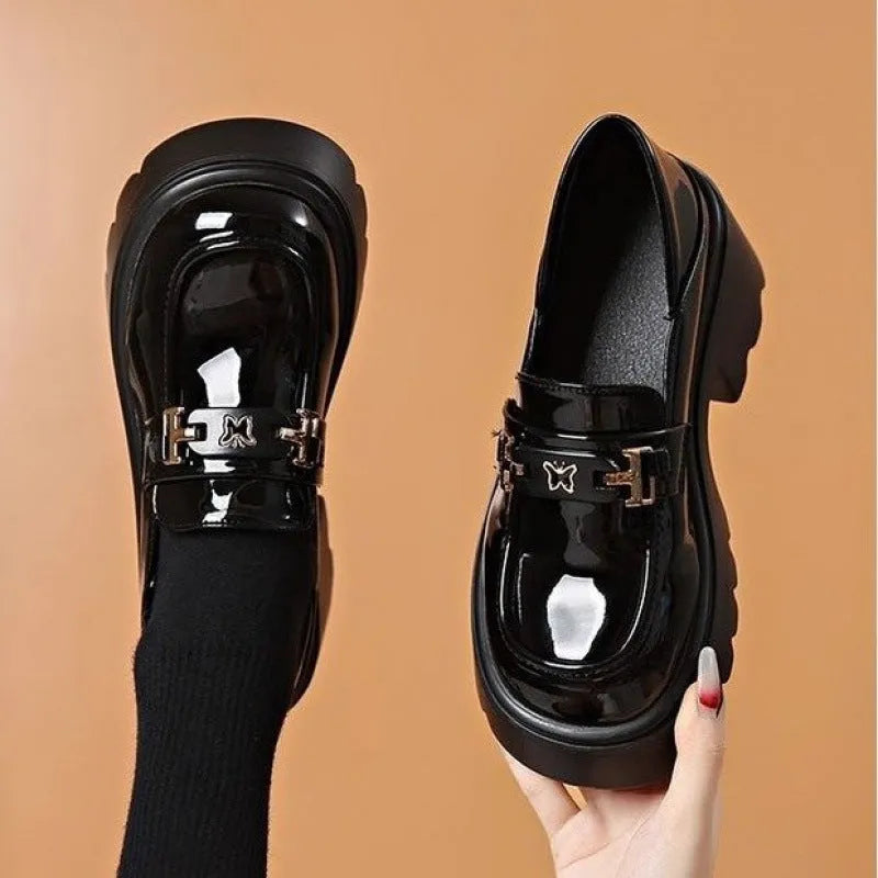 Black slip-on chunky heel shoes with a skull pattern on the front and a square rubber sole.