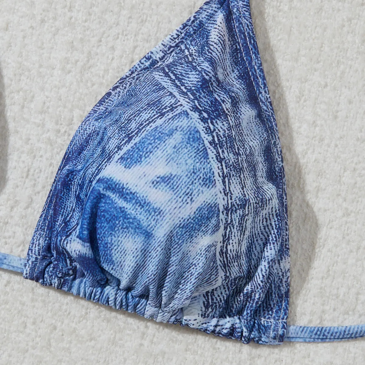 Denim blue printed women's bikini set with strap design on a mannequin, showing top and bottom.
