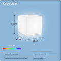 A modern, square white LED cube light functioning as a waterproof outdoor stool.
