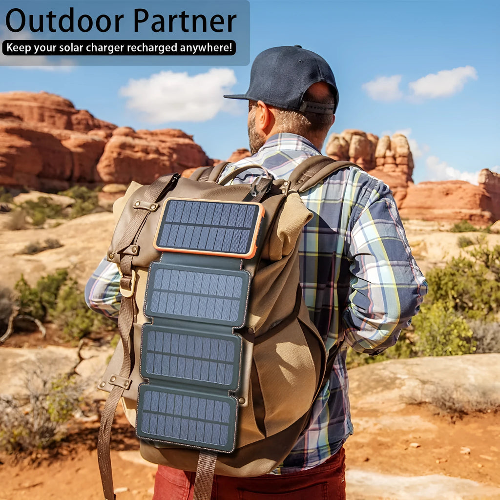Black outdoor solar power bank with a solar panel and a built-in LED light displayed on a rock.