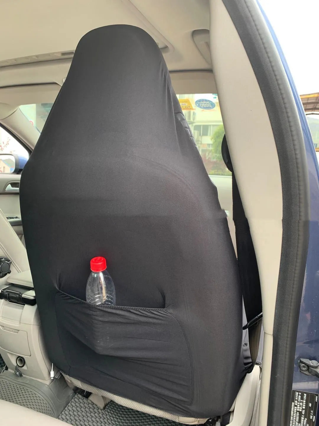 Black quilted automotive seat cover made of PU leather composite material with plastic hooks.