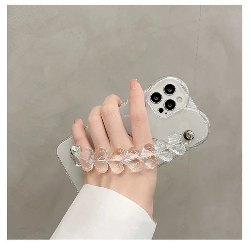 Transparent iPhone case with an attached clear love heart charm bracelet on a TPU shell.