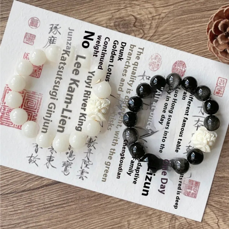 Handcrafted Xingshi obsidian prayer bead bracelet with chamfered square grain design, shown in 12mm size.
