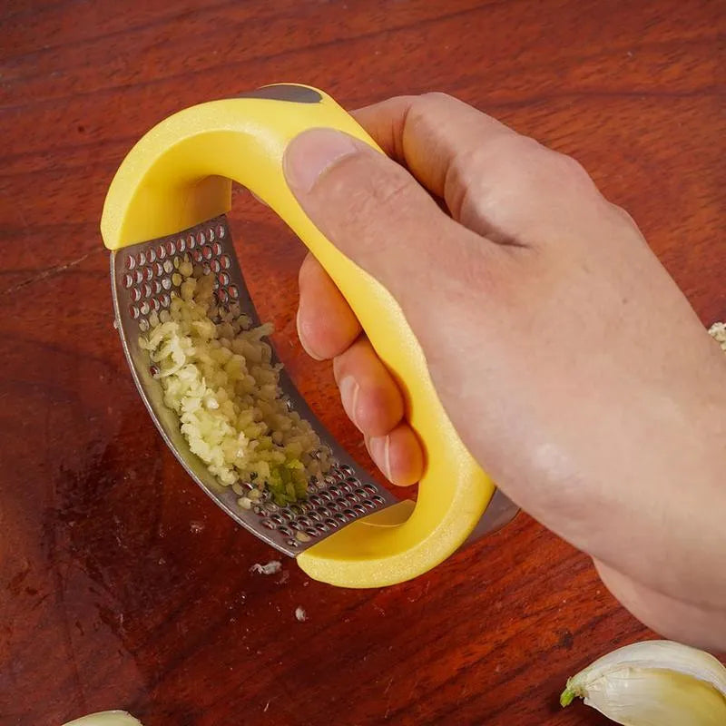 Stainless steel garlic press with non-slip handle in available colours crushing garlic