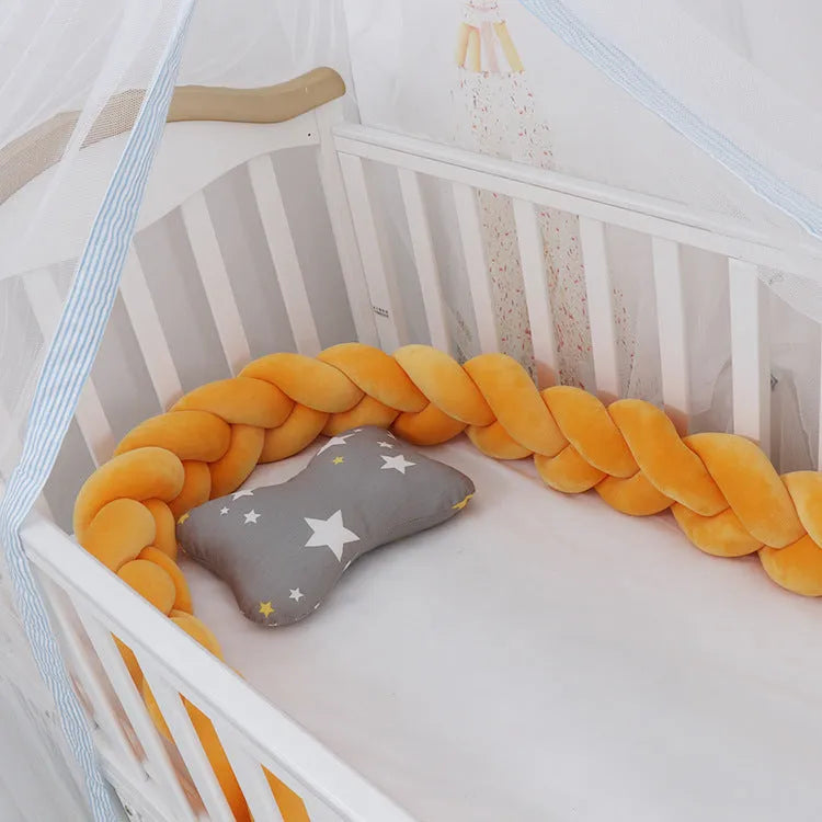 Bendable braid knot baby crib bumper in spandex velvet fabric on a white cot.