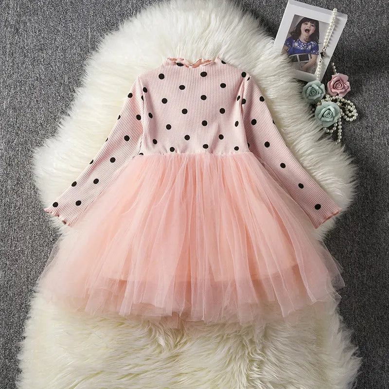 Baby girl in a long sleeve white lace tutu dress for a christening or birthday party.