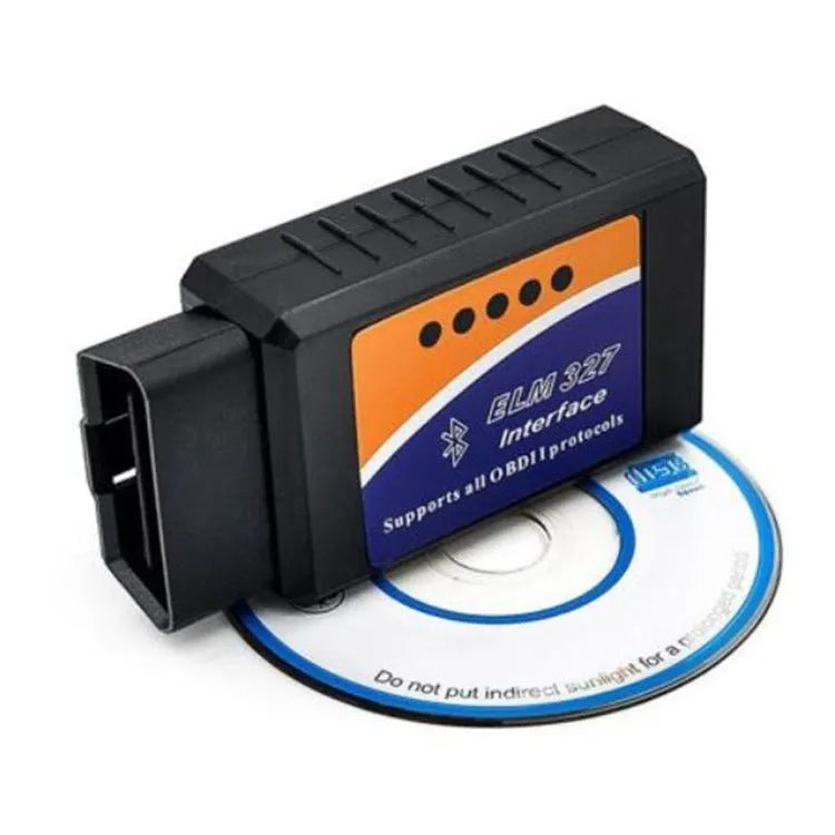 Small black Bluetooth OBD2 car diagnostic scanner next to a vehicle's diagnostic port