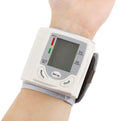 Grey wrist blood pressure monitor with compact rectangular design and display screen