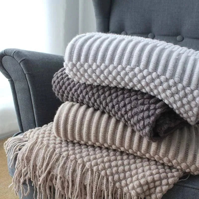 Small light grey polyester throw blanket folded on a sofa, showing its compact 127x170cm size.