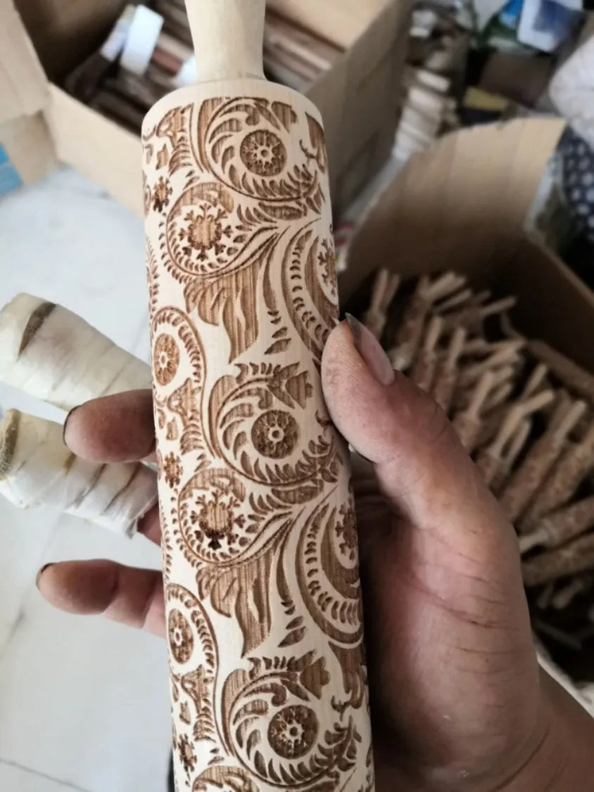 Wooden rolling pin with embossed Christmas patterns including reindeer and snowflakes on a 45cm length.