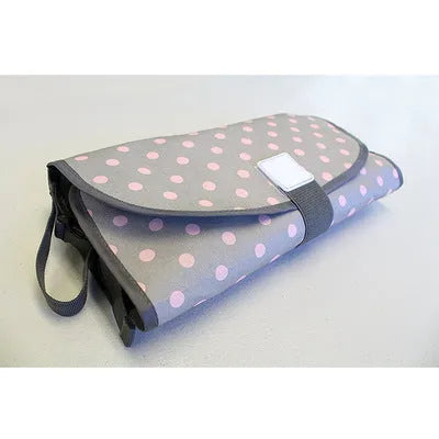 Portable baby diaper changing mat in yellow geometric pattern, 70x50cm, with toy ring and wrist strap unfolded on floor