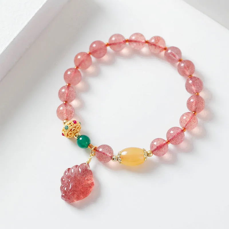 Women's crystal beaded bracelet with a strawberry quartz nine tail fox charm on a white background.