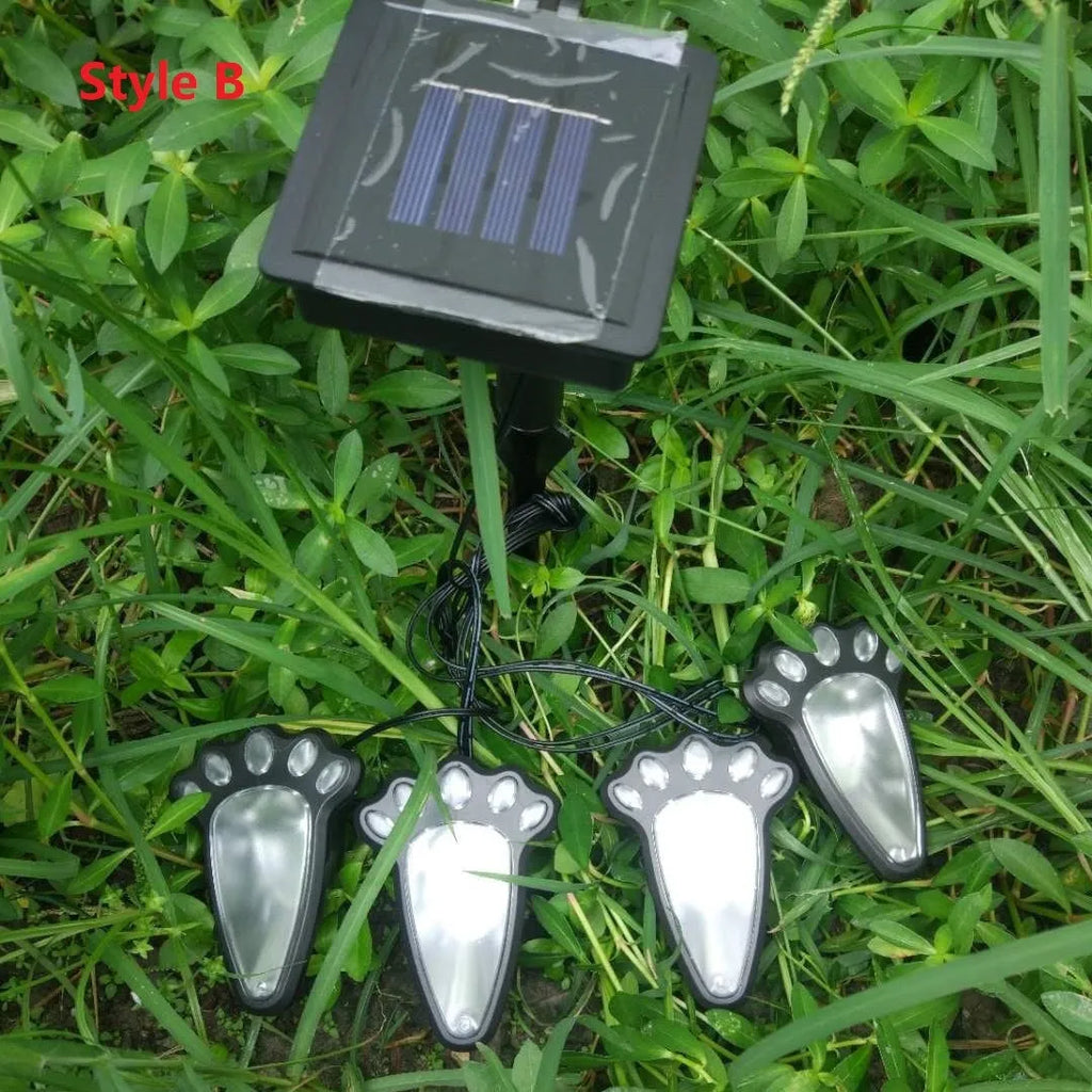 Black solar powered animal paw print garden lights with four paw-shaped LED lamps