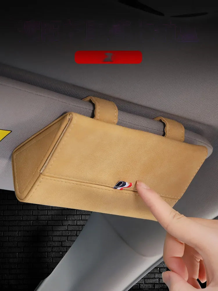 Suede car glasses storage box in beige attached to car sun visor holding sunglasses and phone