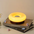 Donut-shaped rechargeable touch table lamp in custard colour with three colour temperature settings
