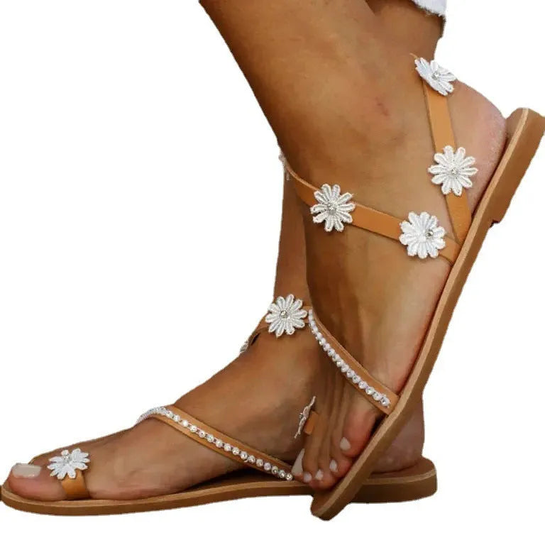 Brown women's flat Roman-style sandals with floral design on the artificial PU upper.