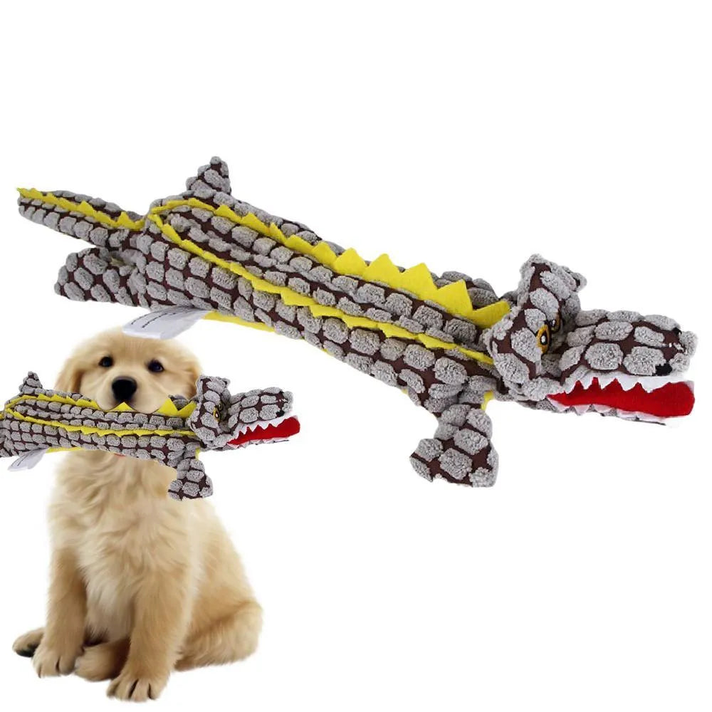 Blue plush crocodile-shaped dog toy with corduroy texture and squeaker, shown next to measuring tape
