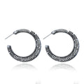 Pair of vintage engraved C-shaped alloy earrings in bronze finish, showing detailed etching.