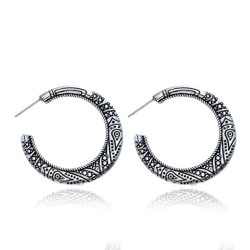 Pair of vintage engraved C-shaped alloy earrings in bronze finish, showing detailed etching.