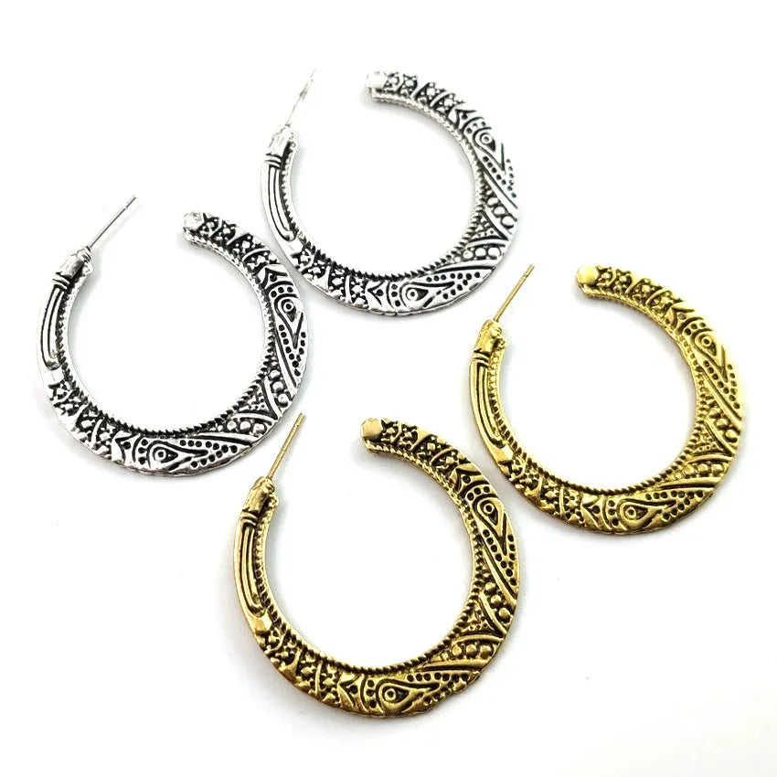 Pair of vintage engraved C-shaped alloy earrings in bronze finish, showing detailed etching.