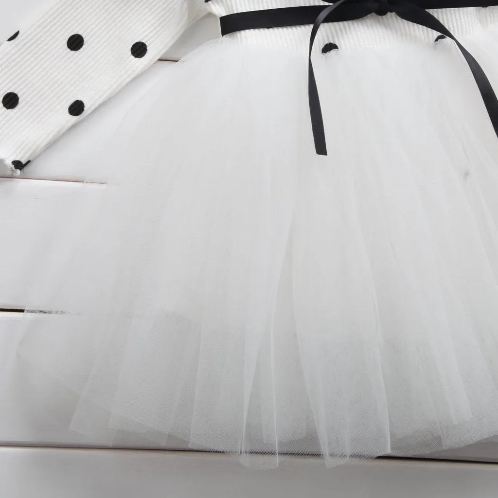 Baby girl in a long sleeve white lace tutu dress for a christening or birthday party.