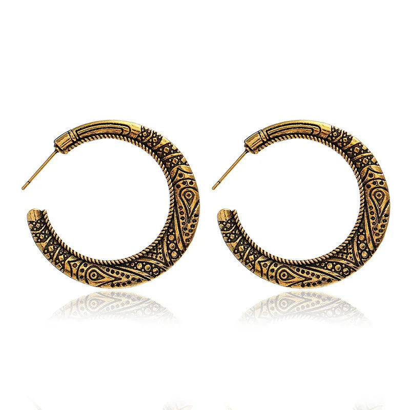 Pair of vintage engraved C-shaped alloy earrings in bronze finish, showing detailed etching.
