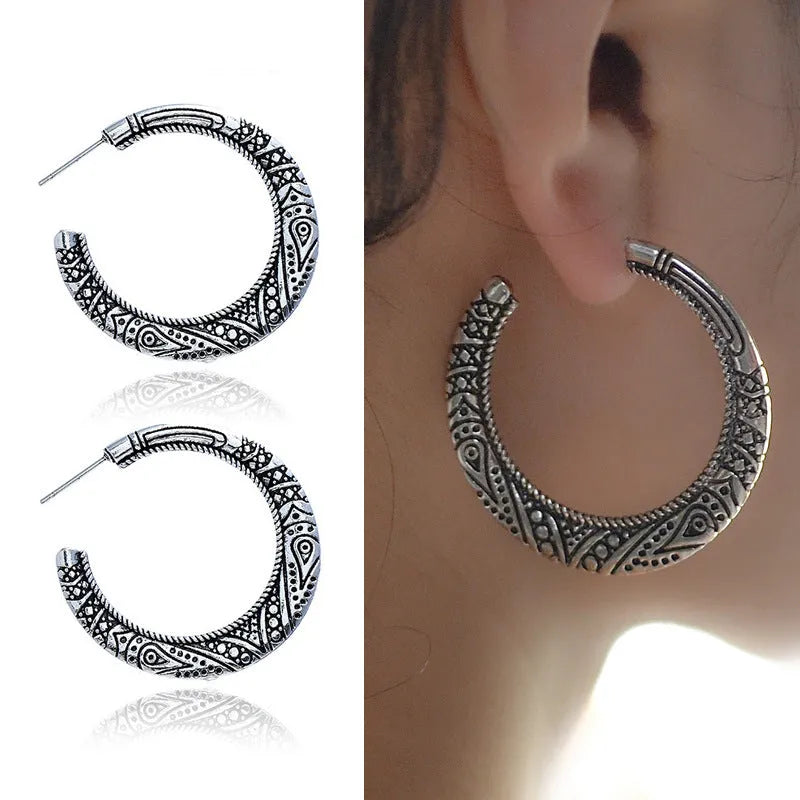 Pair of vintage engraved C-shaped alloy earrings in bronze finish, showing detailed etching.